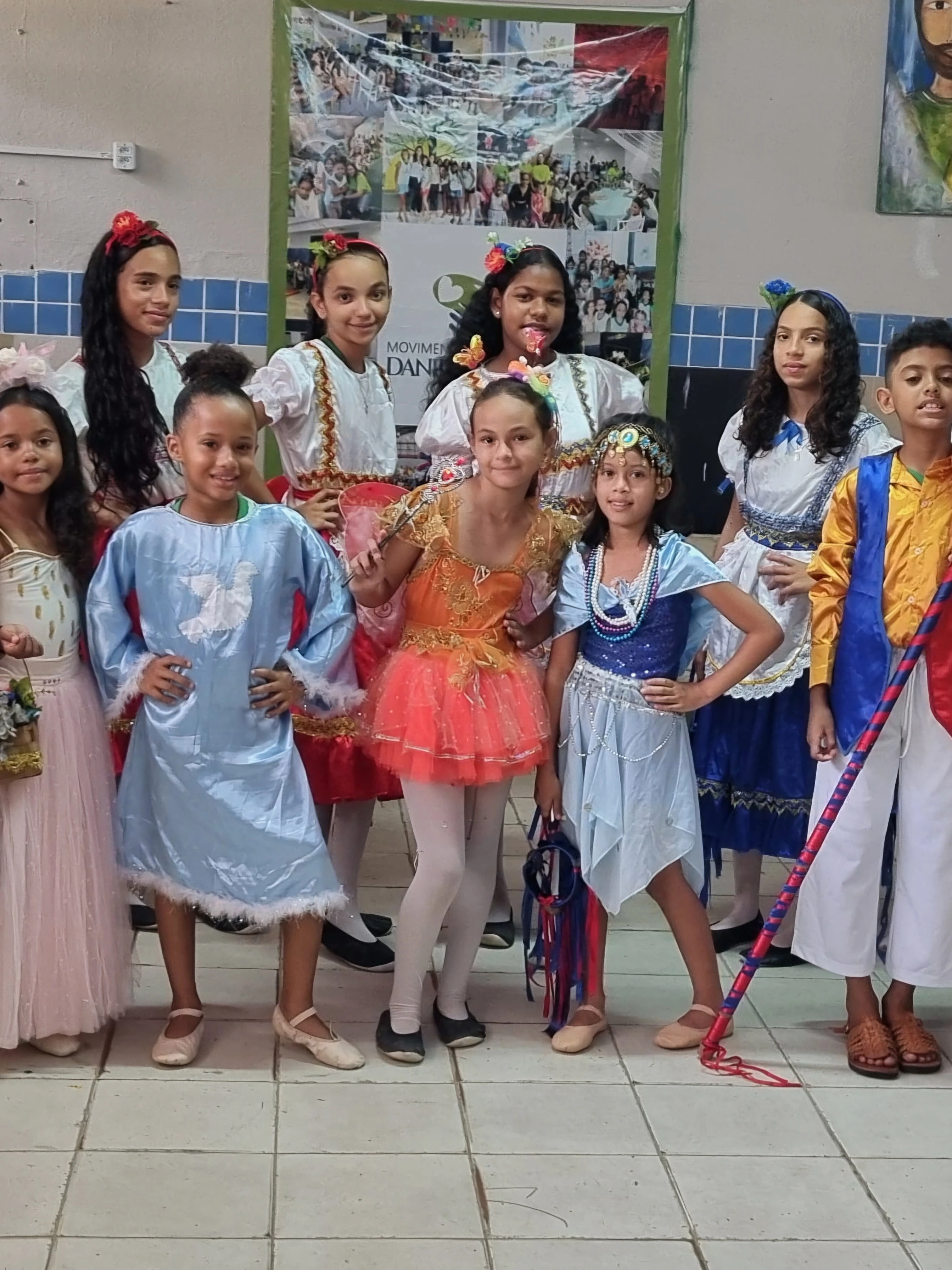 Crianças vestidas com roupas tradicionais de pastoril durante uma apresentação cultural