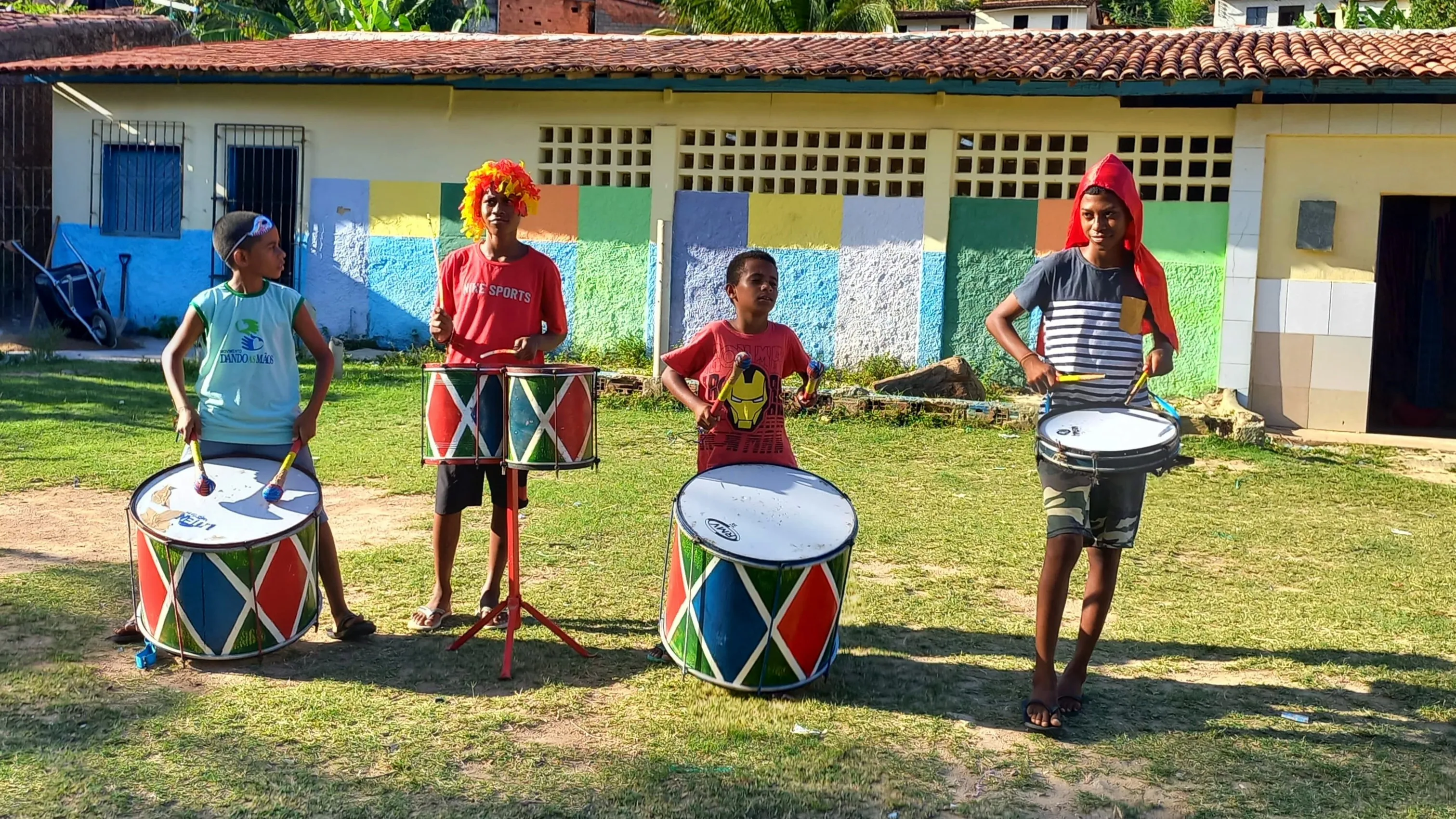 Crianças tocando instrumentos em banda de percussão