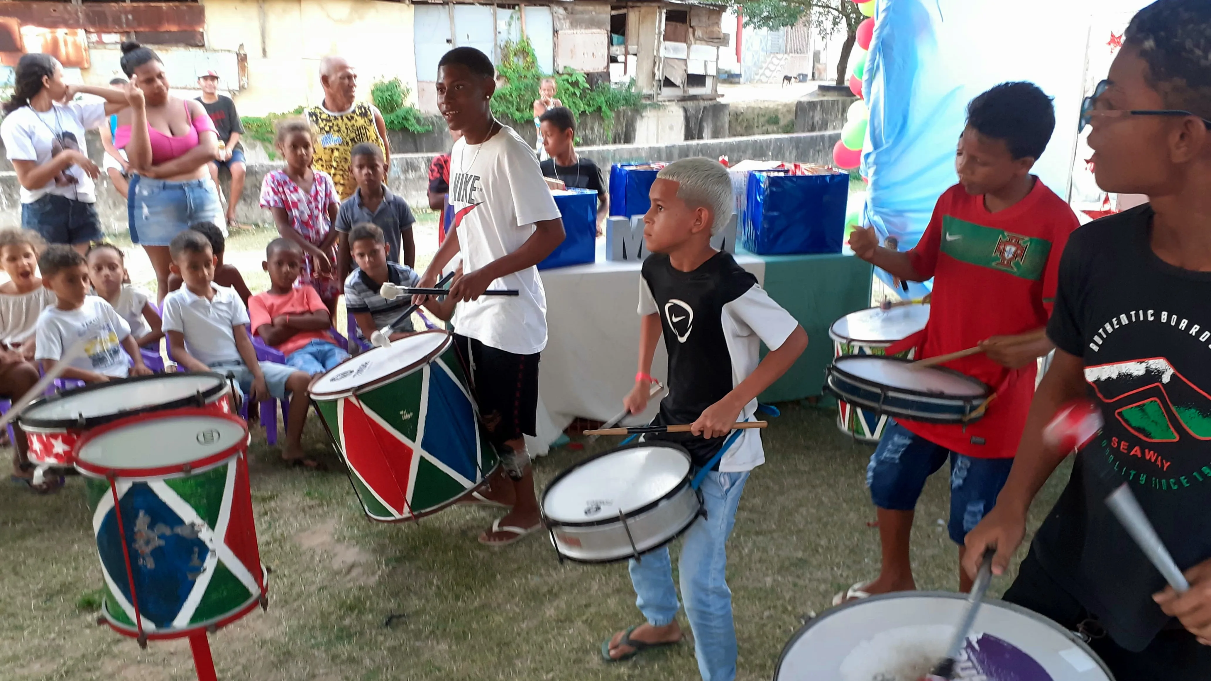 Crianças tocando instrumentos em banda de percussão