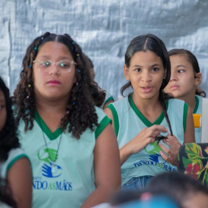 Imagem de crianças atentas a uma apresentação